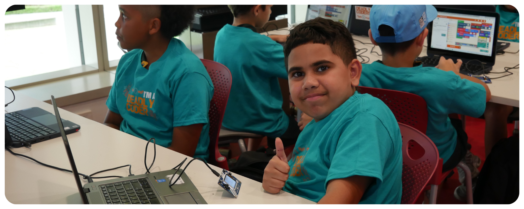 A young Indigenous student gives a thumbs up for his Deadly Coders program